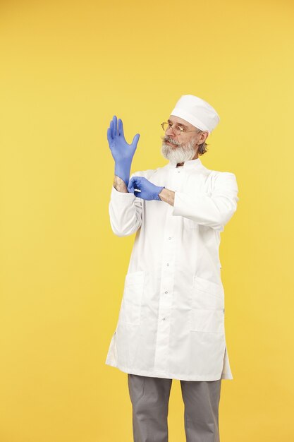 Doctor en medicina sonriente en vasos. Aislado. Hombre en guantes azules.