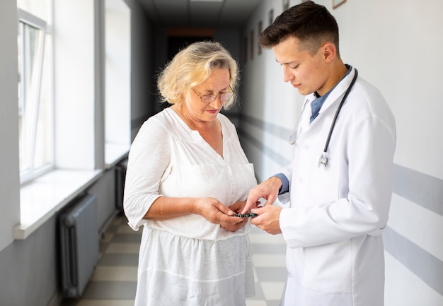 Doctor mostrando píldoras pacientes para tratamiento