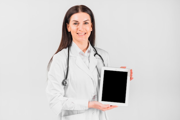Doctor mujer sonriendo y mostrando tableta