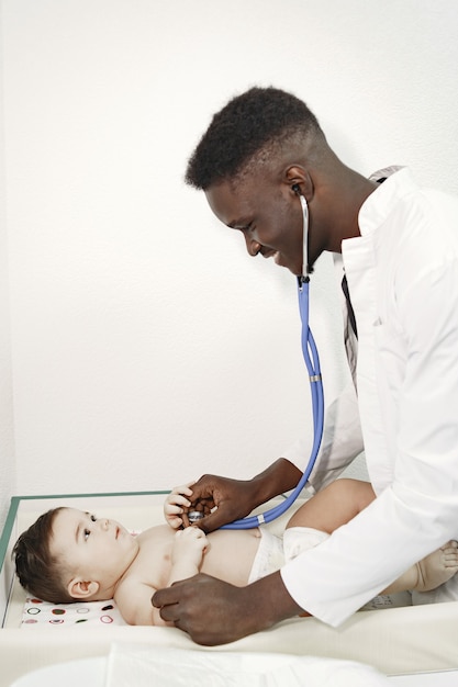 Doctor negro. bebé en pañal. africano con estetoscopio.