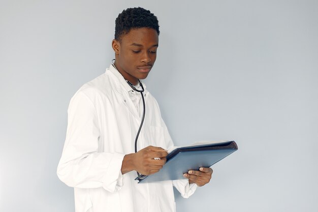 Doctor negro en un uniforme blanco con un estetoscopio
