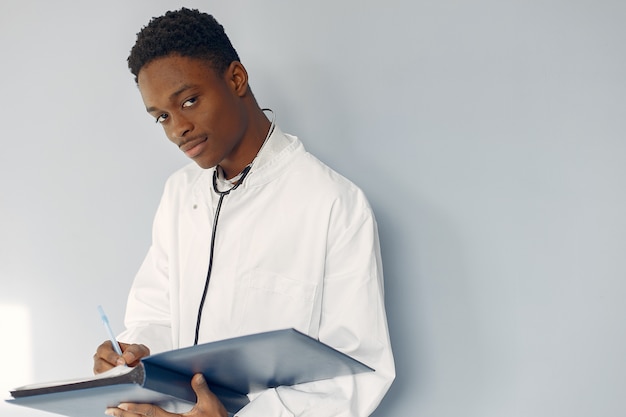 Doctor negro en un uniforme blanco con un estetoscopio