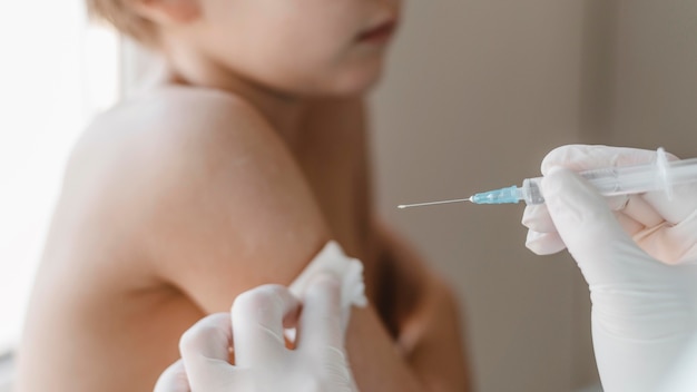 Doctor con niño recibiendo una vacuna