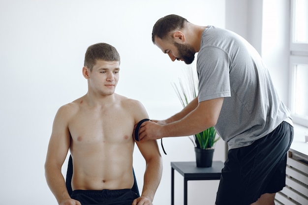 El doctor pega un tipi a un atleta en el hospital