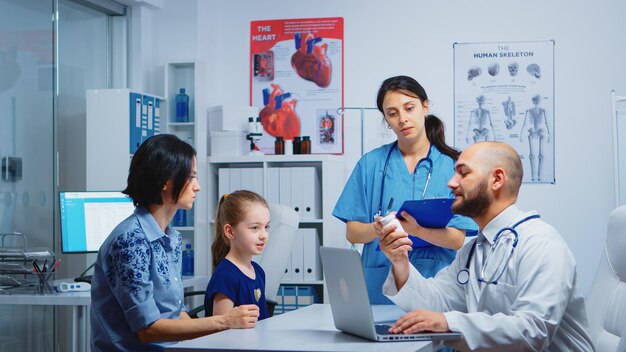 Doctor pidiendo pastillas a la enfermera durante la consulta en el consultorio médico. Médico especialista en medicina que brinda servicios de atención médica consulta tratamiento de examen de diagnóstico en gabinete de hospital