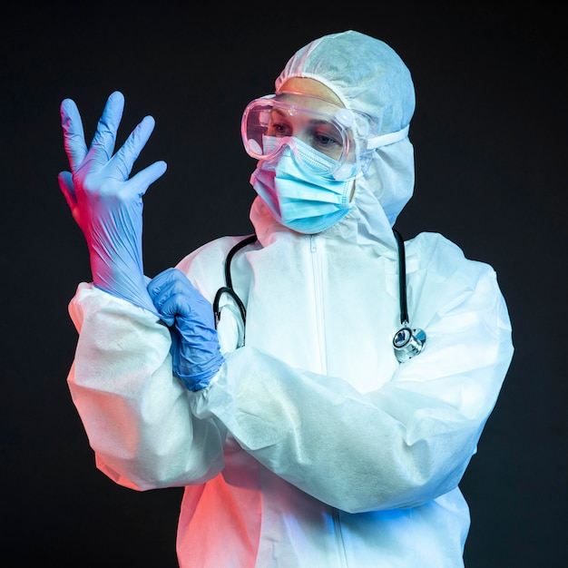 Doctor con ponerse guantes quirúrgicos