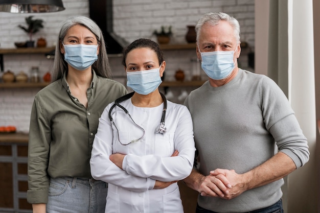 Doctor posando con sus pacientes detrás