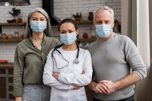 Doctor posando con sus pacientes detrás