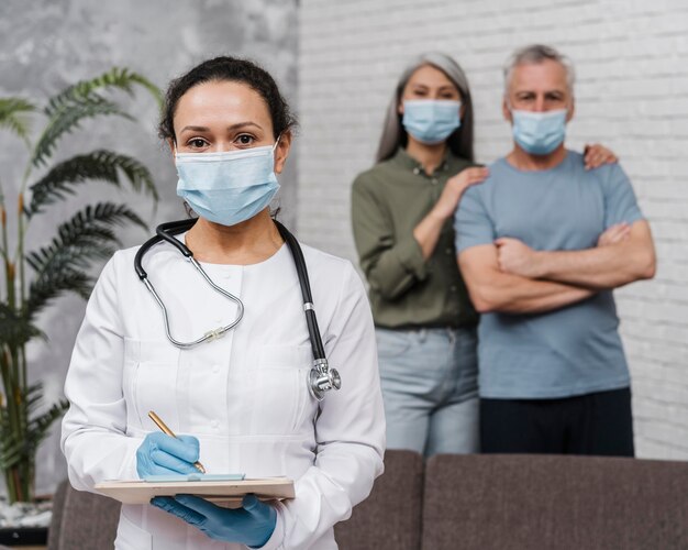 Doctor posando con sus pacientes detrás