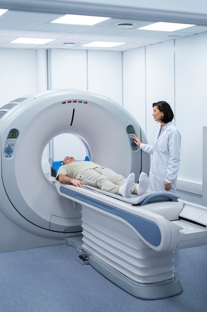 Doctor preparando al paciente para la tomografía computarizada