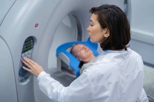 Doctor preparando al paciente para la tomografía computarizada