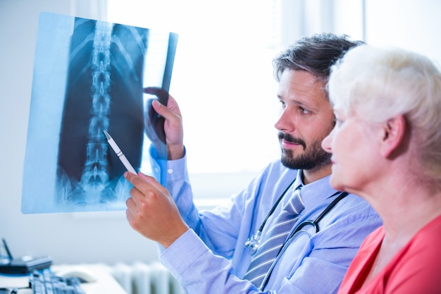 Doctor que discute la radiografía con el paciente