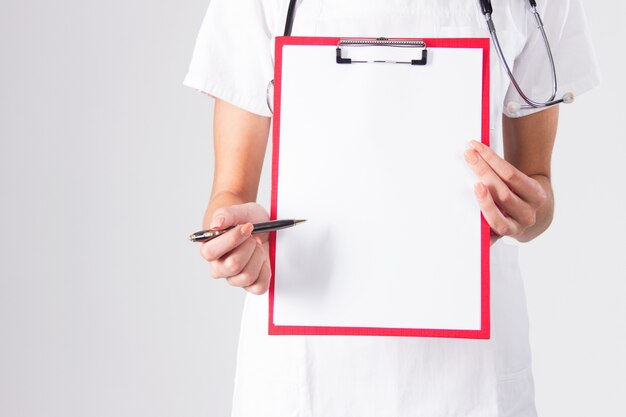 Doctor que muestra el sujetapapeles en blanco con la pluma aislada en un fondo blanco.