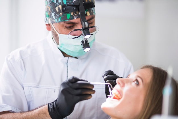 Doctor revisando los dientes del paciente femenino en la clínica