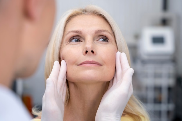 Foto gratuita doctor revisando mujer sonriente de cerca