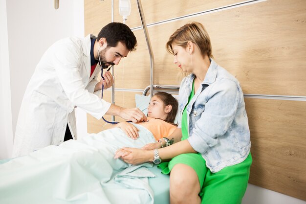 Doctor revisando su corazón paciente en el hospital