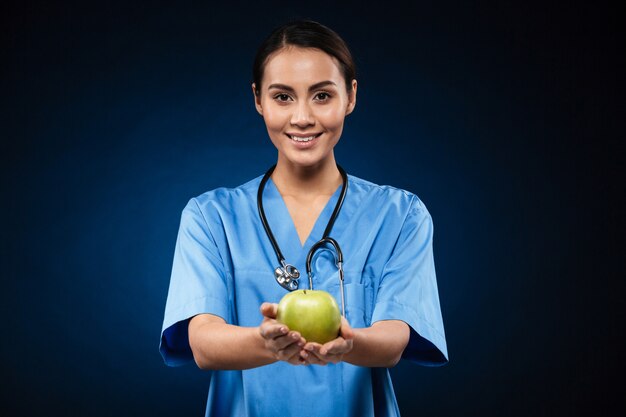 Doctor sano feliz que sostiene la manzana verde aislada