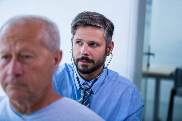 Doctor de sexo masculino examina a un paciente