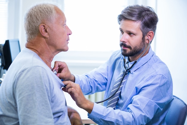 Doctor de sexo masculino examina a un paciente