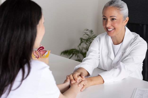 Doctor sonriente de alto ángulo sosteniendo las manos del paciente