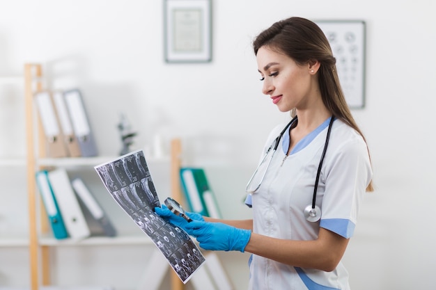 Foto gratuita doctor sonriente mirando una radiografía