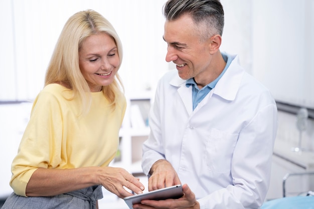 Foto gratuita doctor sonriente y paciente de tiro medio