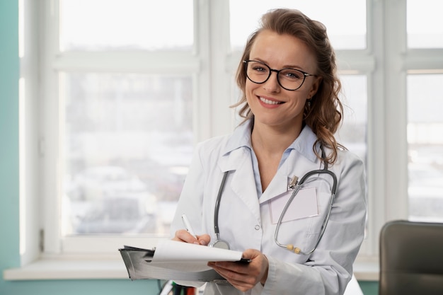 Doctor sonriente de tiro medio con bata blanca