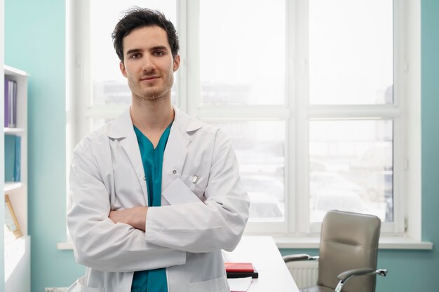 Doctor sonriente de tiro medio con los brazos cruzados