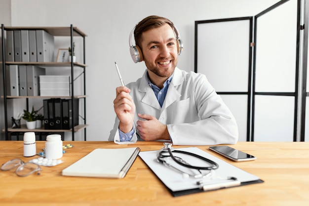 Doctor sonriente de tiro medio sosteniendo la pluma