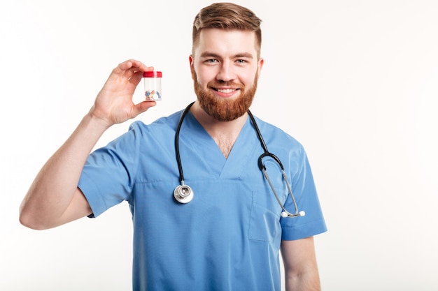 Doctor sosteniendo una botella con tabletas o píldoras para el tratamiento