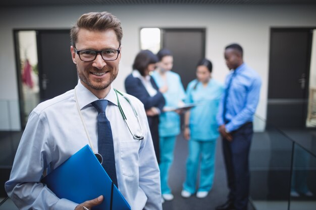 Doctor sosteniendo informe médico en el pasillo del hospital