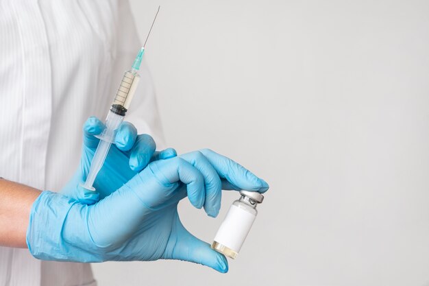 Doctor sosteniendo jeringa con vacuna