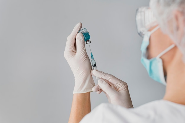 Foto gratuita doctor sosteniendo una jeringa para una vacuna