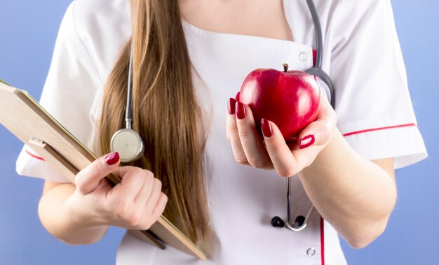 Doctor sosteniendo manzana roja en la mano