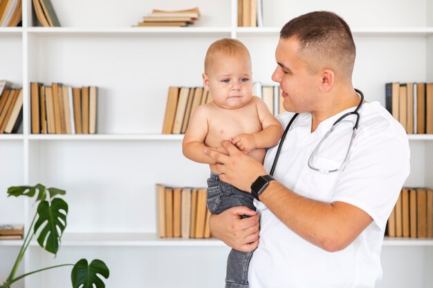 Doctor sosteniendo medio bebé desnudo