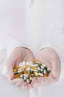 Foto gratuita doctor sosteniendo un montón de pastillas