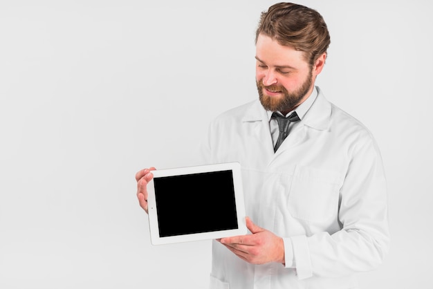 Doctor sosteniendo tableta y mirando gadget