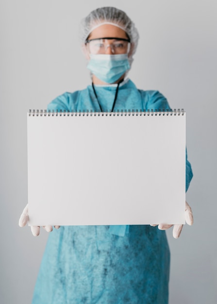 Doctor sosteniendo una tarjeta en blanco
