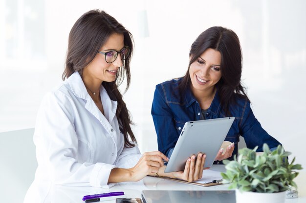 El doctor y su paciente escogiendo la prótesis mamaria en la oficina.