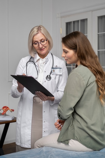 Doctor de tiro medio hablando con paciente