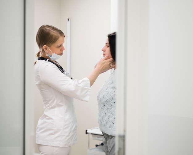 Doctor de tiro medio que controla al paciente