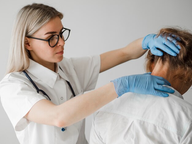 Doctor de tiro medio que controla al paciente