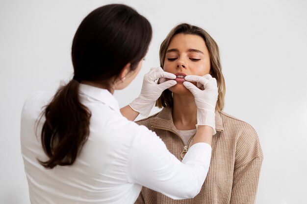 Doctor de tiro medio revisando mujer