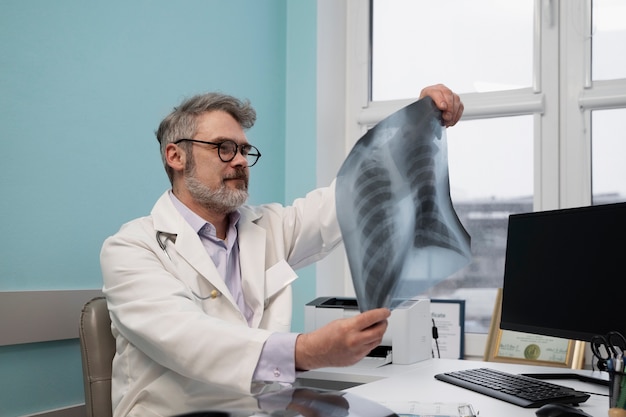 Doctor de tiro medio revisando radiografía