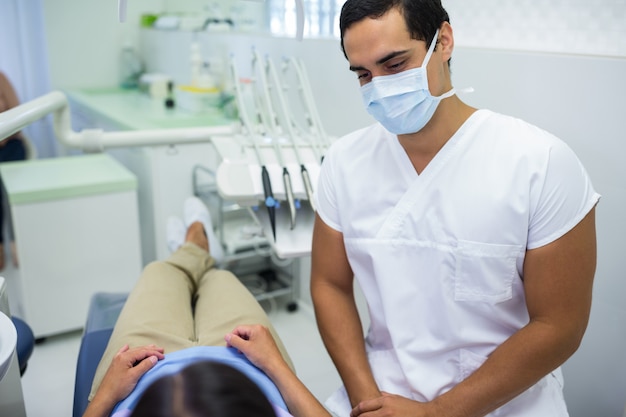 Doctor usando mascarilla quirúrgica con paciente femenino