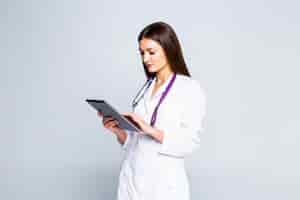 Foto gratuita doctor usando una tableta aislada sobre una pared blanca