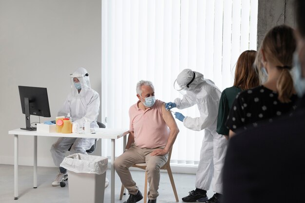 Doctor vacunando a un paciente en un centro