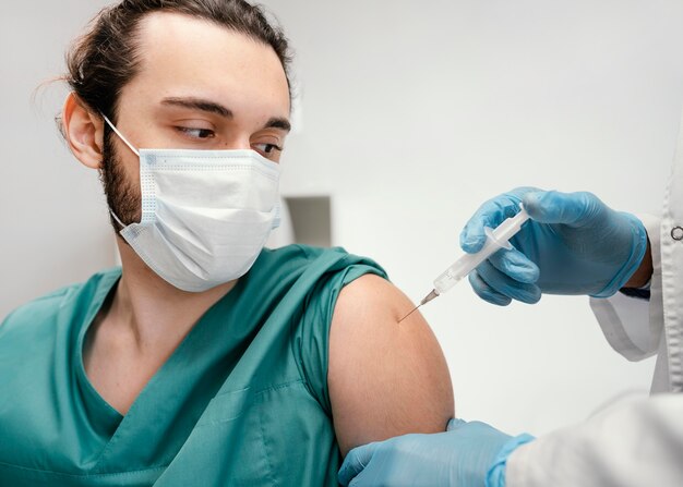 Doctor vacunando a un paciente en la clínica.