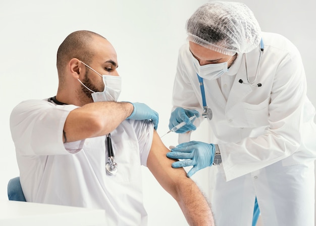 Doctor vacunando a un paciente en la clínica.