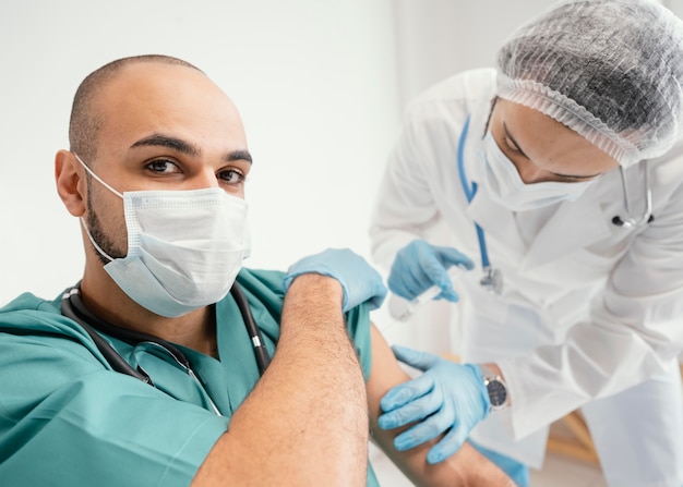 Doctor vacunando a un paciente en la clínica.